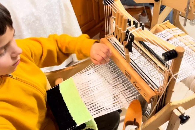 enfant tissant une écharpe